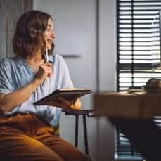 Smiling woman taking notes with a tablet during a training session