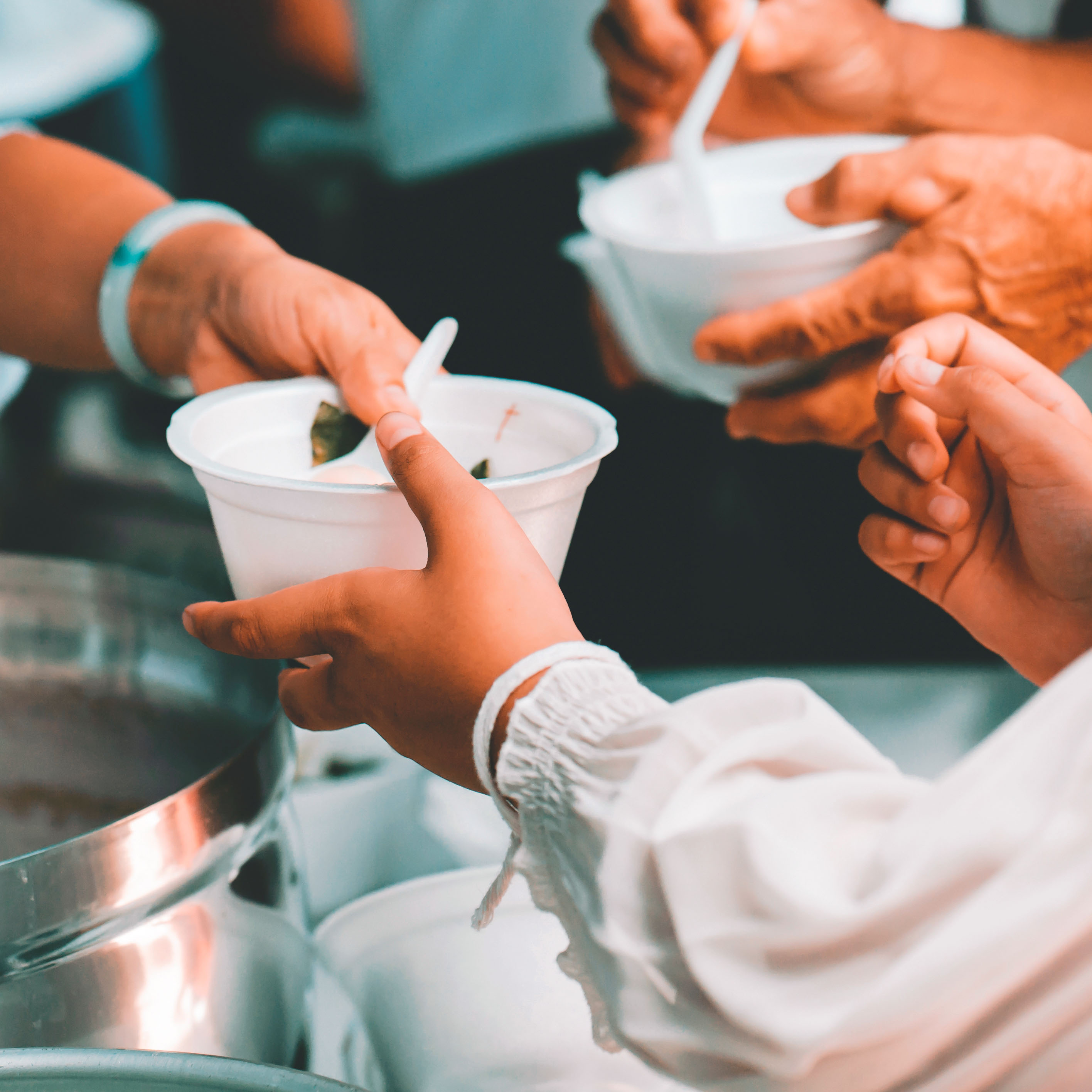 Hands handing over a bowl of food